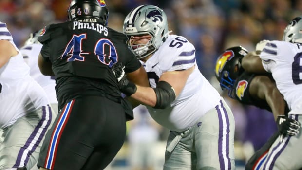 Kansas State senior offensive lineman cooper Beebe (50) keeps Kansas redshirt senior defensive lineman Devin Phillips (40) at bay during the second quarter of Saturday's Sunflower Showdown inside David Booth Kansas Memorial Stadium.
